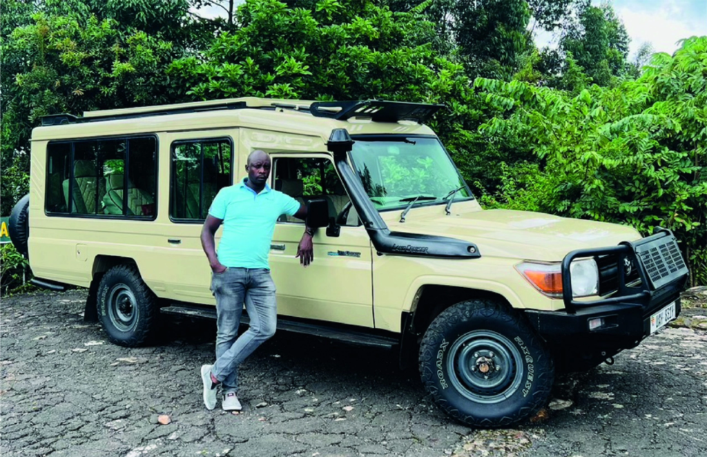 Private safari guide beside a pop-top Land Cruiser in Uganda